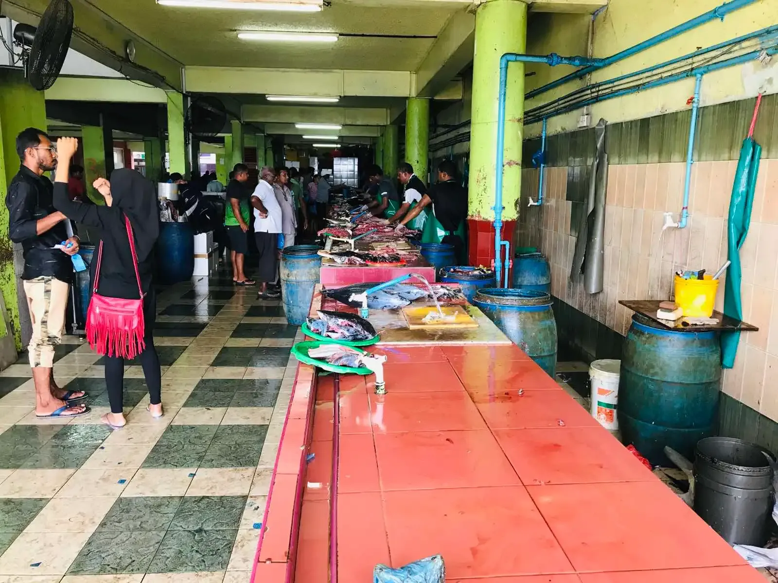 Tuna laid out on long tables inside the fish market in Malé